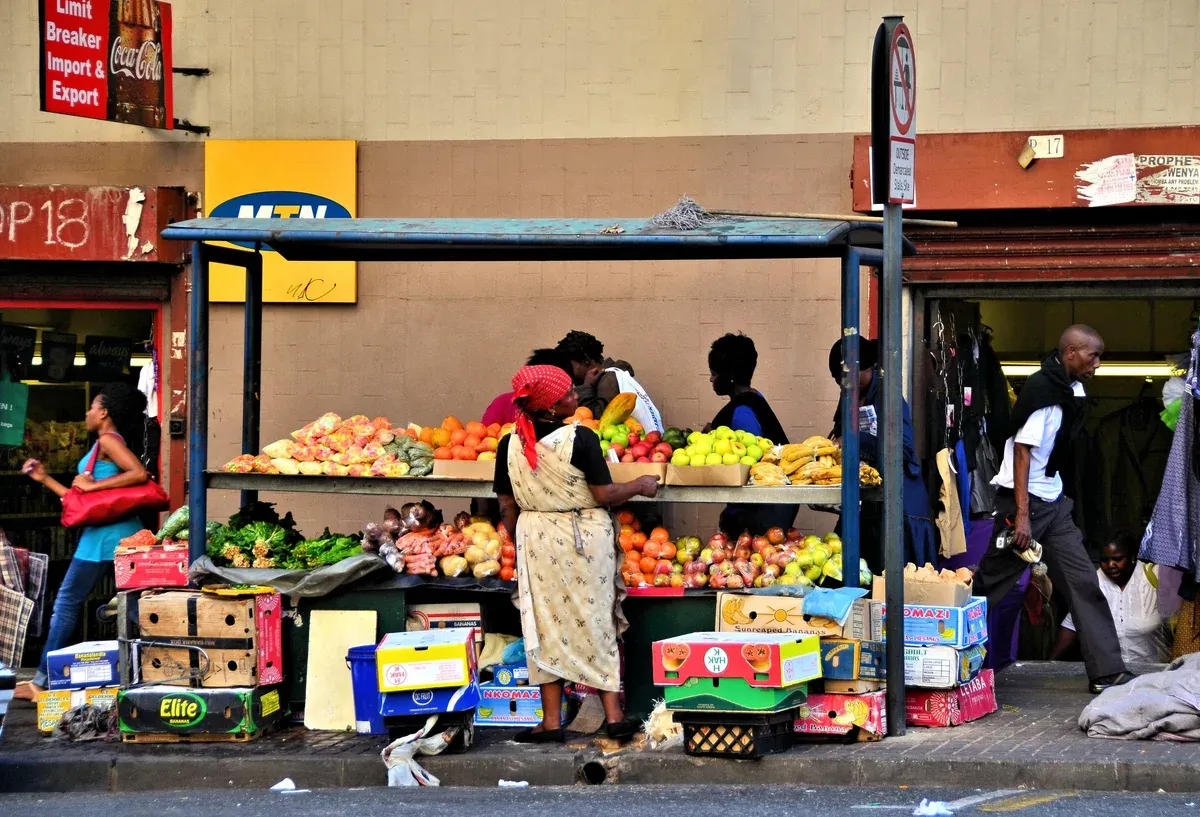 A street vendor's fruit display at a Johannesburg pavement stall, piles of produce in the open air