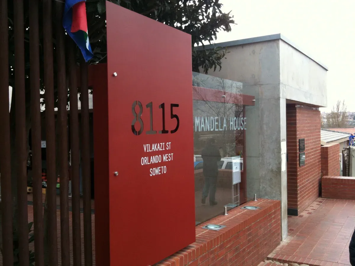 The red-brick facade of Mandela House at 8115 Vilakazi Street with its single door and small windows